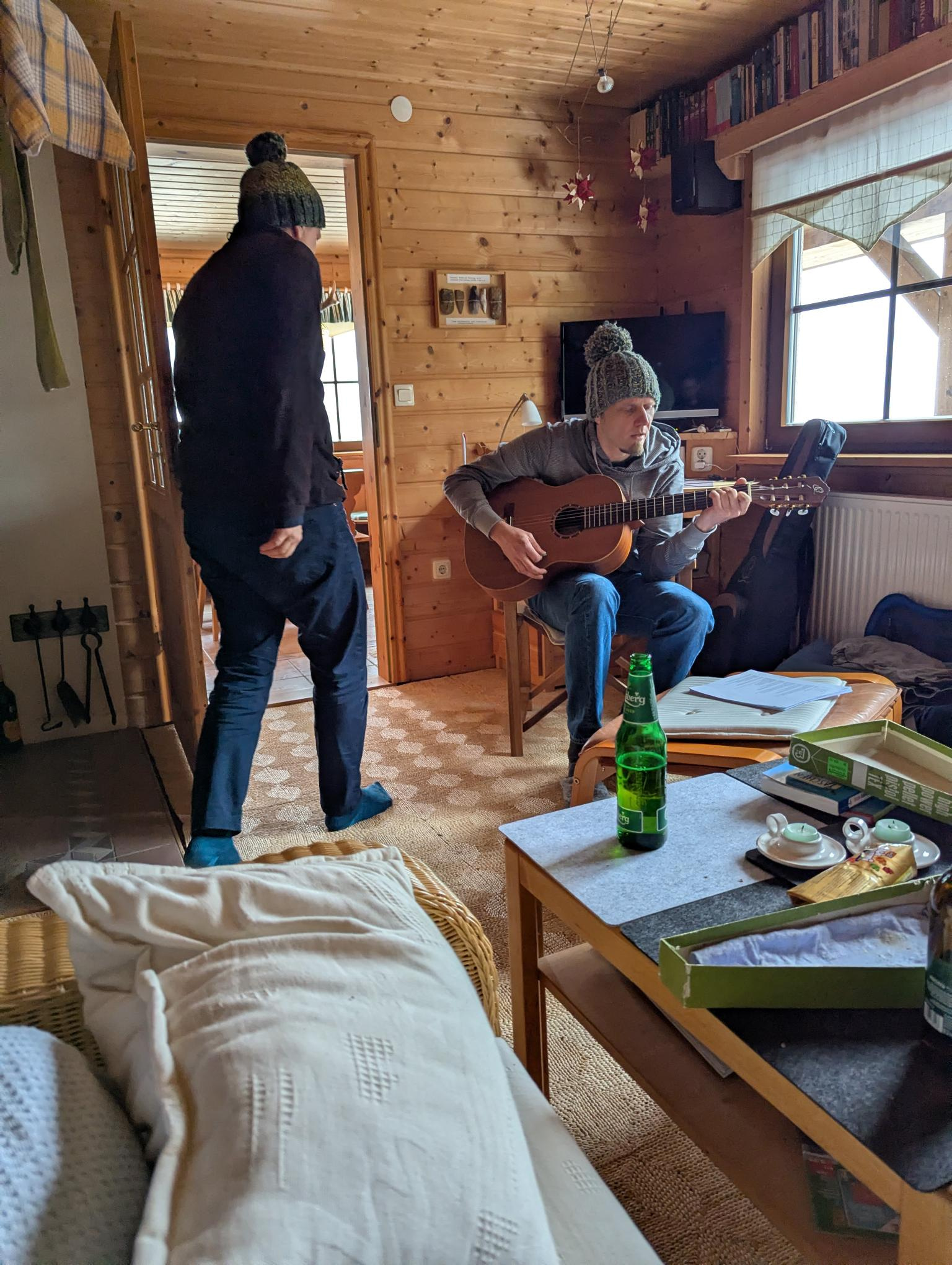 Zwei Personen in einem Raum mit Holzwänden und -decken.