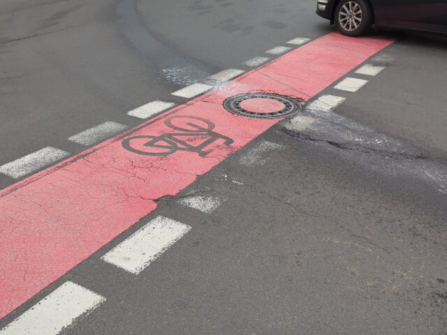 Fahrbahnmarkierung und Fahrzeug in Wohngebiet