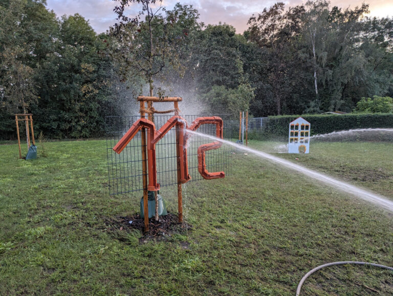 Wasserspiel mit der Notrufnummer 112 in Benndorf Ein Wasserstrahl trifft beim Feuerwehr-Vereinsfest auf eine aus Rohren gebaute 112 auf einer Wiese in Benndorf.