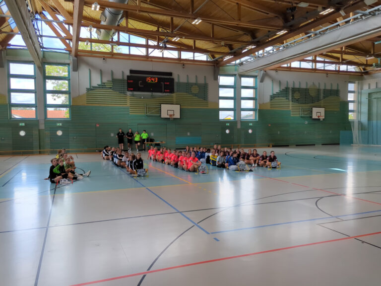 Die fünf Mannschaften des Lober-Cups sitzen nach dem Turnier gemeinsam im Kreis auf dem Hallenboden.