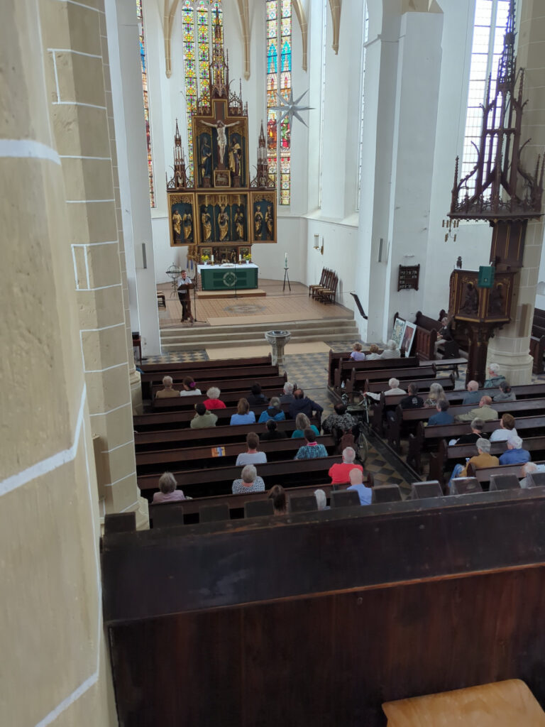 Rund 80 Zuhörerinnen und Zuhörer sitzen bei OrgelPunkt12 in den Bänken der Stadtkirche St. Peter und Paul in Delitzsch.