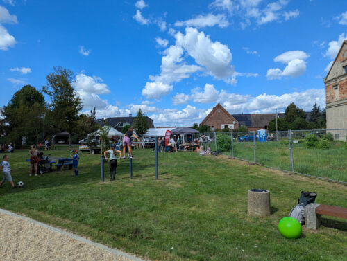 Kinder und Erwachsene feiern bei Ständen und Zelten auf dem Spielplatz Am Herrenhaus in Storkwitz.