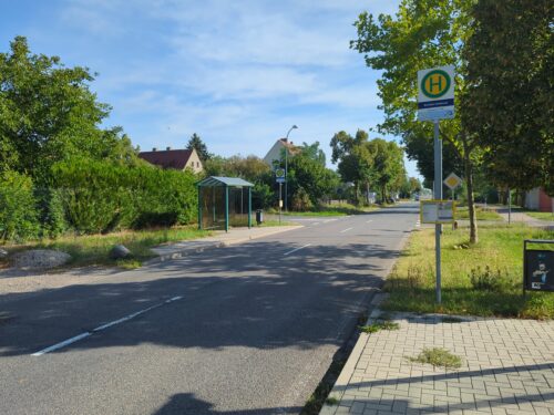 Blick entlang der Kreisstraße auf die zwei gegenüberliegenden Haltepunkte der Bushaltestelle Benndorf.