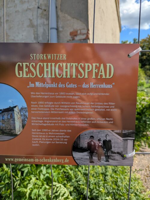 Braune Informationstafel des Storkwitzer Geschichtspfads über die Geschichte und den Zustand des Herrenhauses.