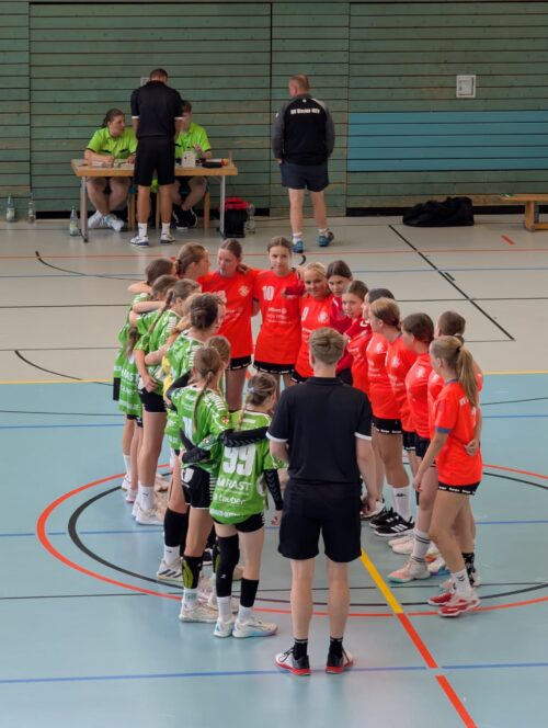 Die Spielerinnen von HV Glesien und SG Kühnau stehen vor dem entscheidenden Spiel gemeinsam mit ihren Trainern im Kreis.