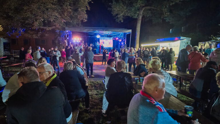 Sommerfest-Abend im Park Döbernitz Gäste unterhalten sich und tanzen vor der Bühne beim abendlichen Sommerfest im Döbernitzer Park.