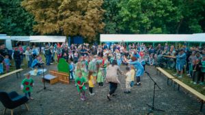 Kinder der Kita Landmäuse führen beim Sommerfest im Döbernitzer Park ein Musical auf; ihre Gesichter sind verpixelt.