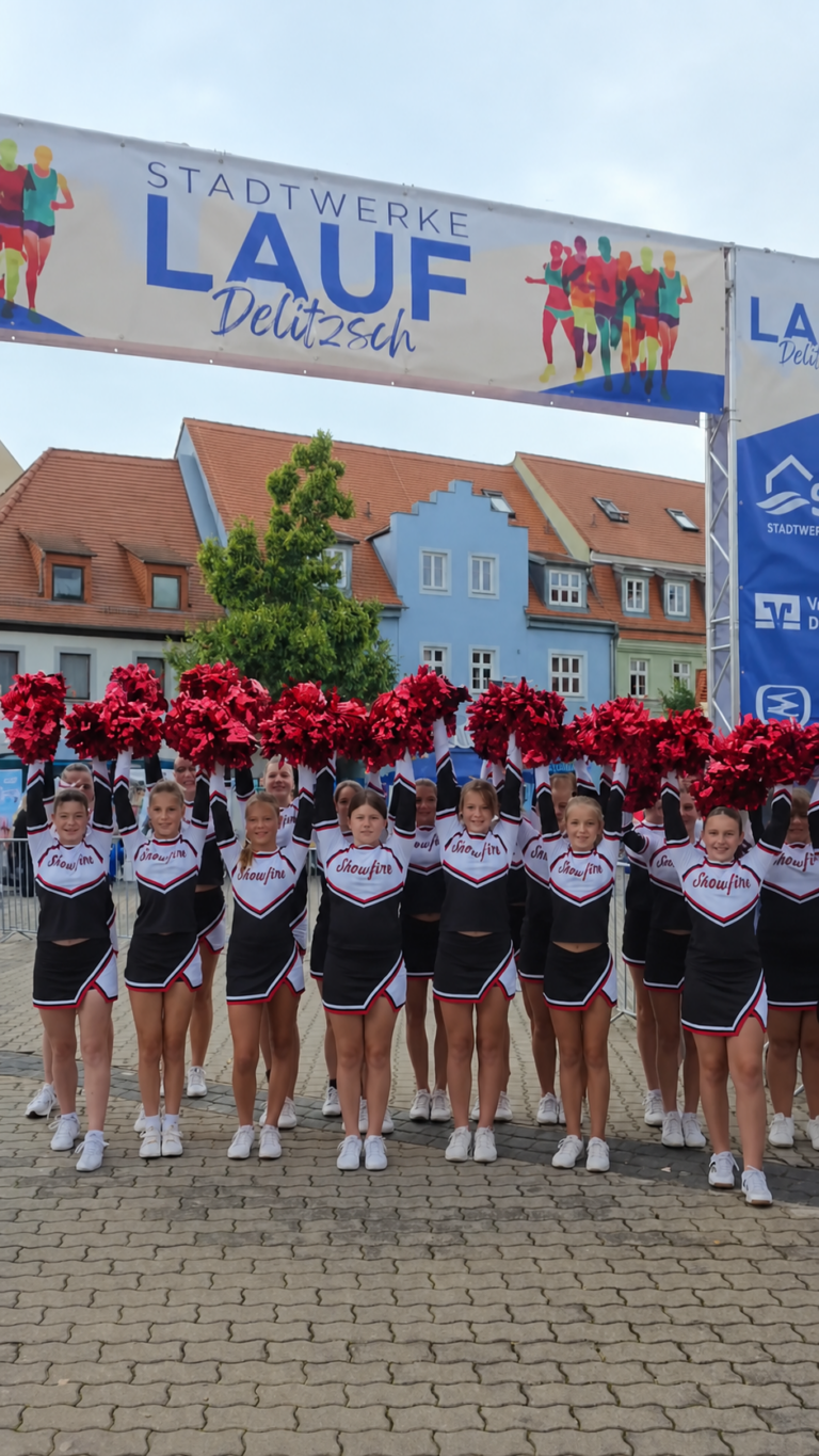 Cheerleader aus Zwochau beim Stadtwerkelauf Cheerleader aus Zwochau stehen mit roten Pompons unter dem Stadtwerkelauf-Bogen am Roßplatz