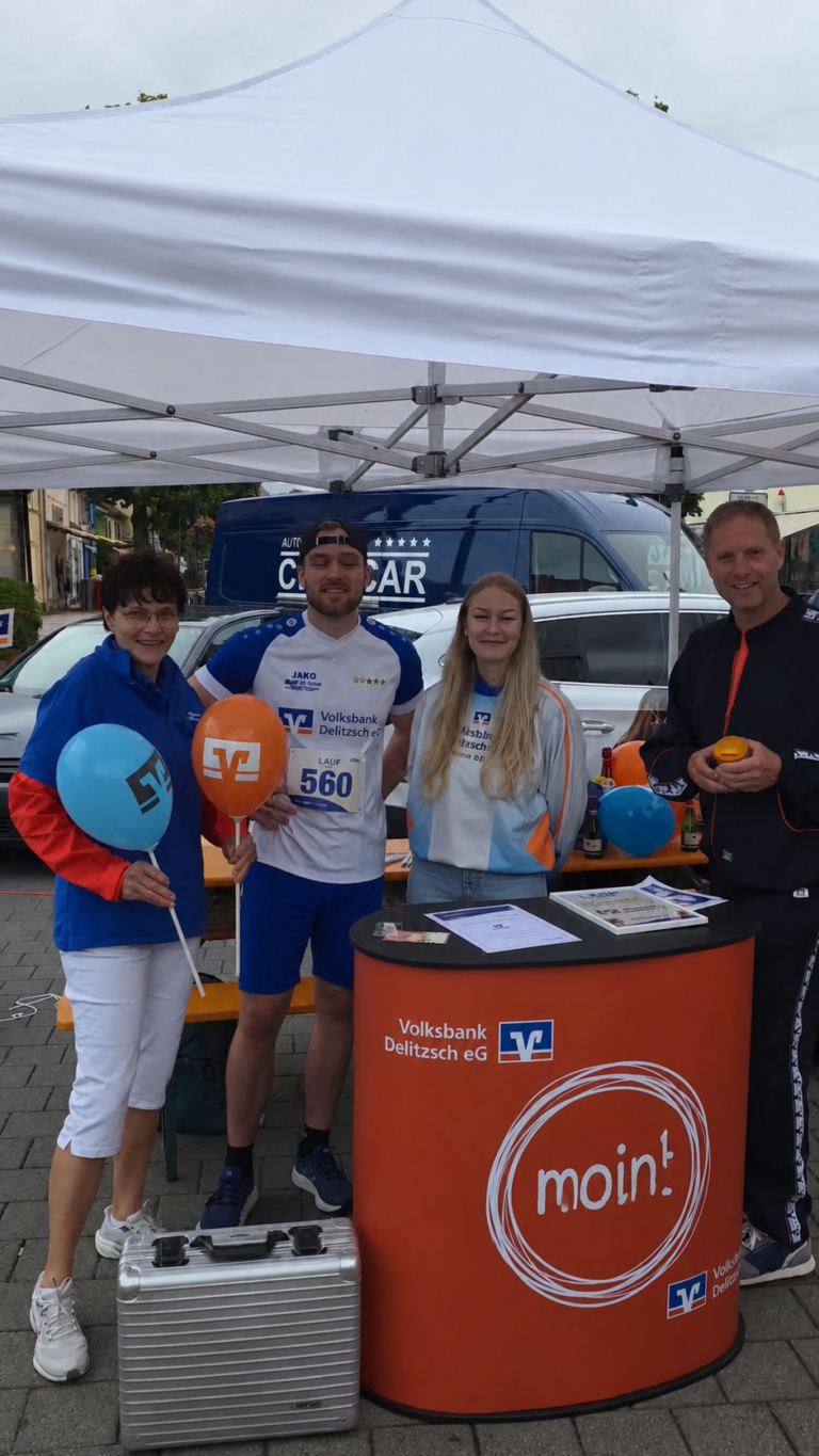 Volksbank Delitzsch beim Stadtwerkelauf Vier Erwachsene am Stand der Volksbank Delitzsch beim Stadtwerkelauf 2026