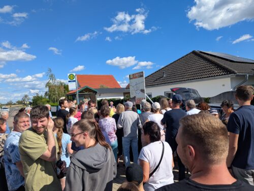 Eine große Menschenmenge steht bei sonnigem Wetter vor der Übersichtstafel des Storkwitzer Geschichtspfads.