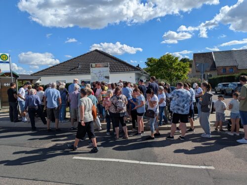 Eine große Besuchergruppe folgt der Führung an der Übersichtstafel des Storkwitzer Geschichtspfads.