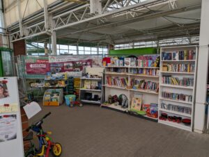 Regale mit Büchern, Spielen, Kleidung und Haushaltswaren in der Gespendet-Ecke des Delitzscher Hallenflohmarkts.