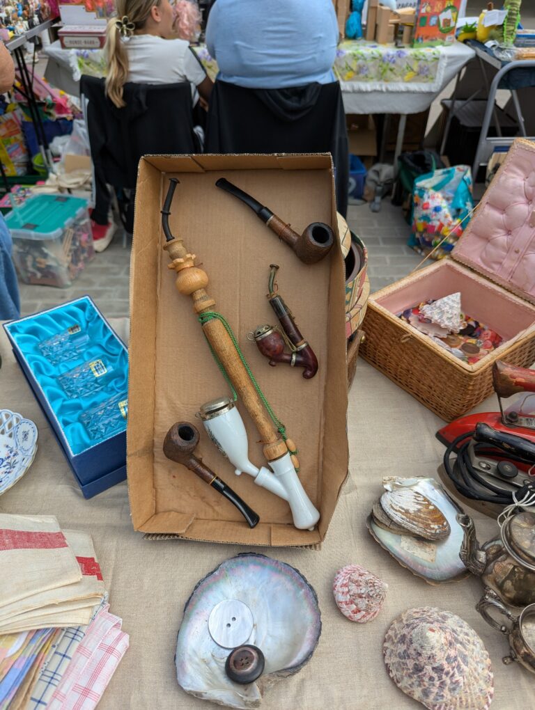 Alte Angelruten, Geschirr und Kleinteile liegen auf einem Verkaufstisch beim Hallenflohmarkt in Delitzsch.