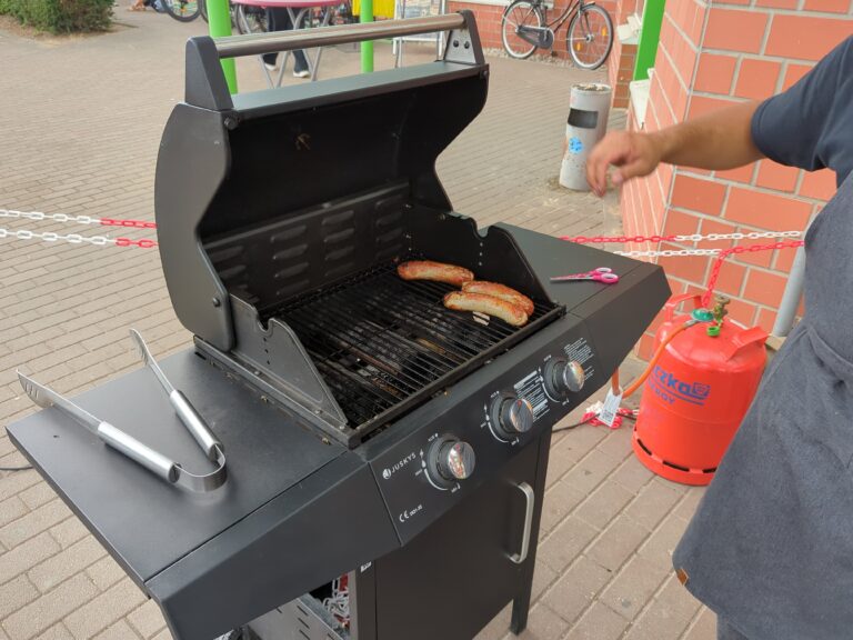 Würstchen liegen auf dem Grill vor der Halle des Delitzscher Hallenflohmarkts.
