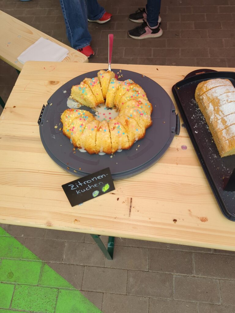 Ein Gugelhupf und einzelne Kuchenstücke liegen am Stand der Löwenklasse beim Hallenflohmarkt in Delitzsch.