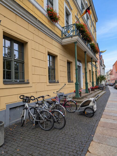 Mehrere Fahrräder und ein Fahrradanhänger stehen vor dem Delitzscher Rathaus.