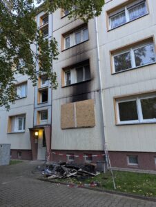 Dunkle Rußspuren ziehen sich über mehrere Fenster an der Fassade eines Mehrfamilienhauses in der F.-C.-Weiskopf-Straße in Delitzsch.