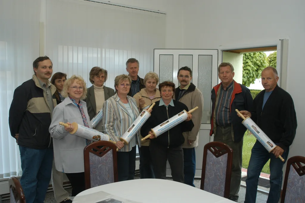 Die ersten Familien der Döbernitzer Dorfkeule Gruppenfoto von Beteiligten mit vier bedruckten Dorfkeulen