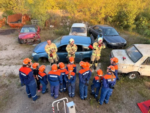 Mitglieder der Jugendfeuerwehr Delitzsch verfolgen eine Einweisung zur technischen Hilfeleistung an mehreren Übungsfahrzeugen.