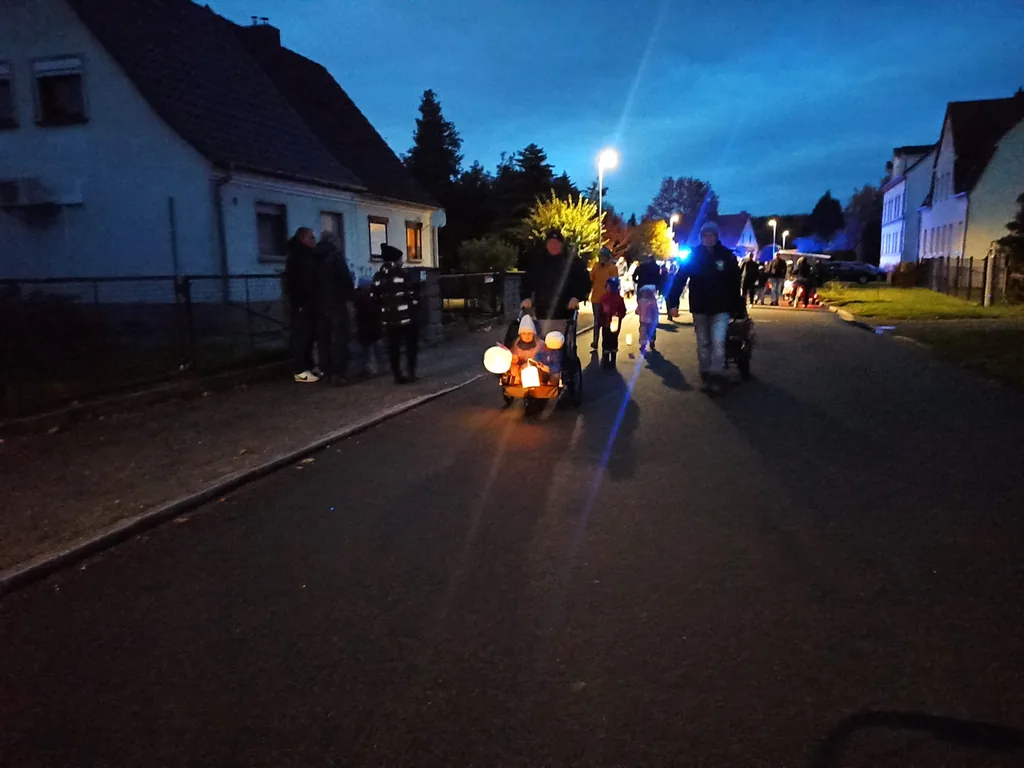 Laternen im Kinderwagen Kinder im Wagen mit leuchtenden Laternen beim Umzug durch Döbernitz, im Hintergrund blaues Licht der Feuerwehr