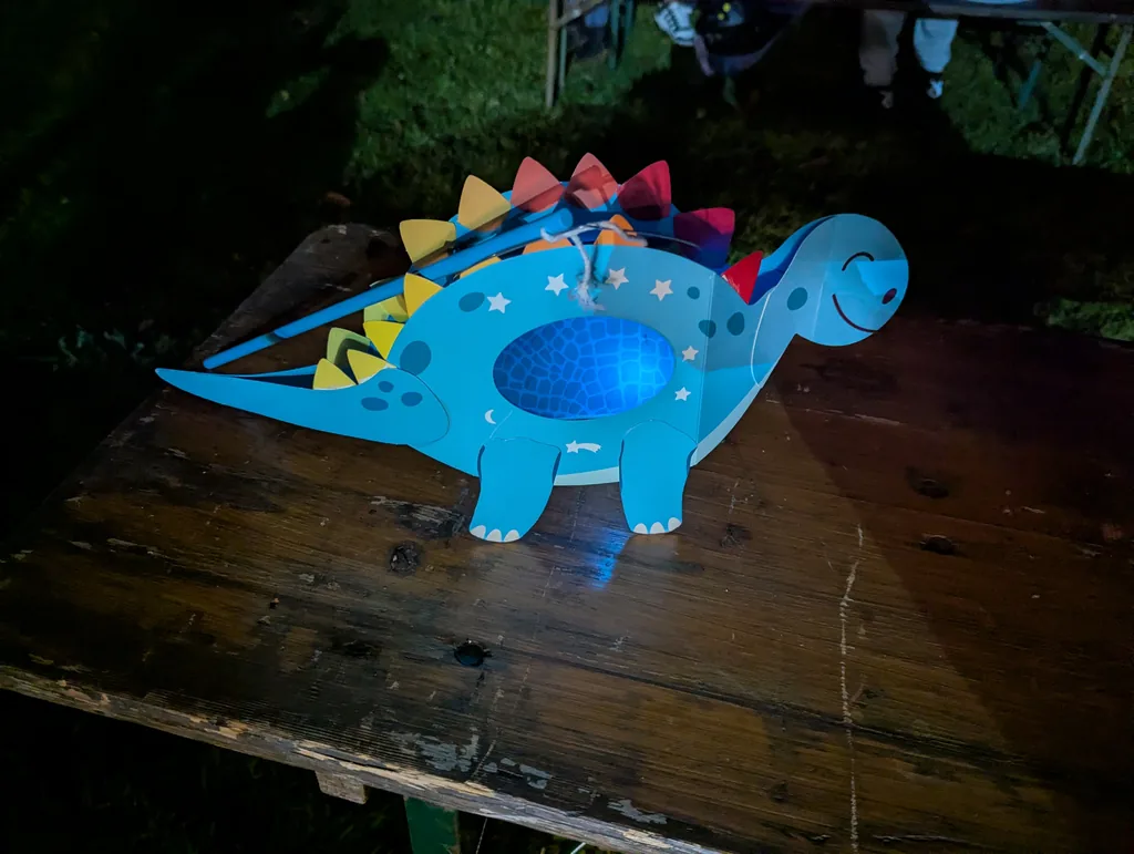 Dinosaurier-Laterne Blaue gebastelte Dinosaurier-Laterne mit bunten Zacken beim Lamping-Jungen-Umzug in Döbernitz